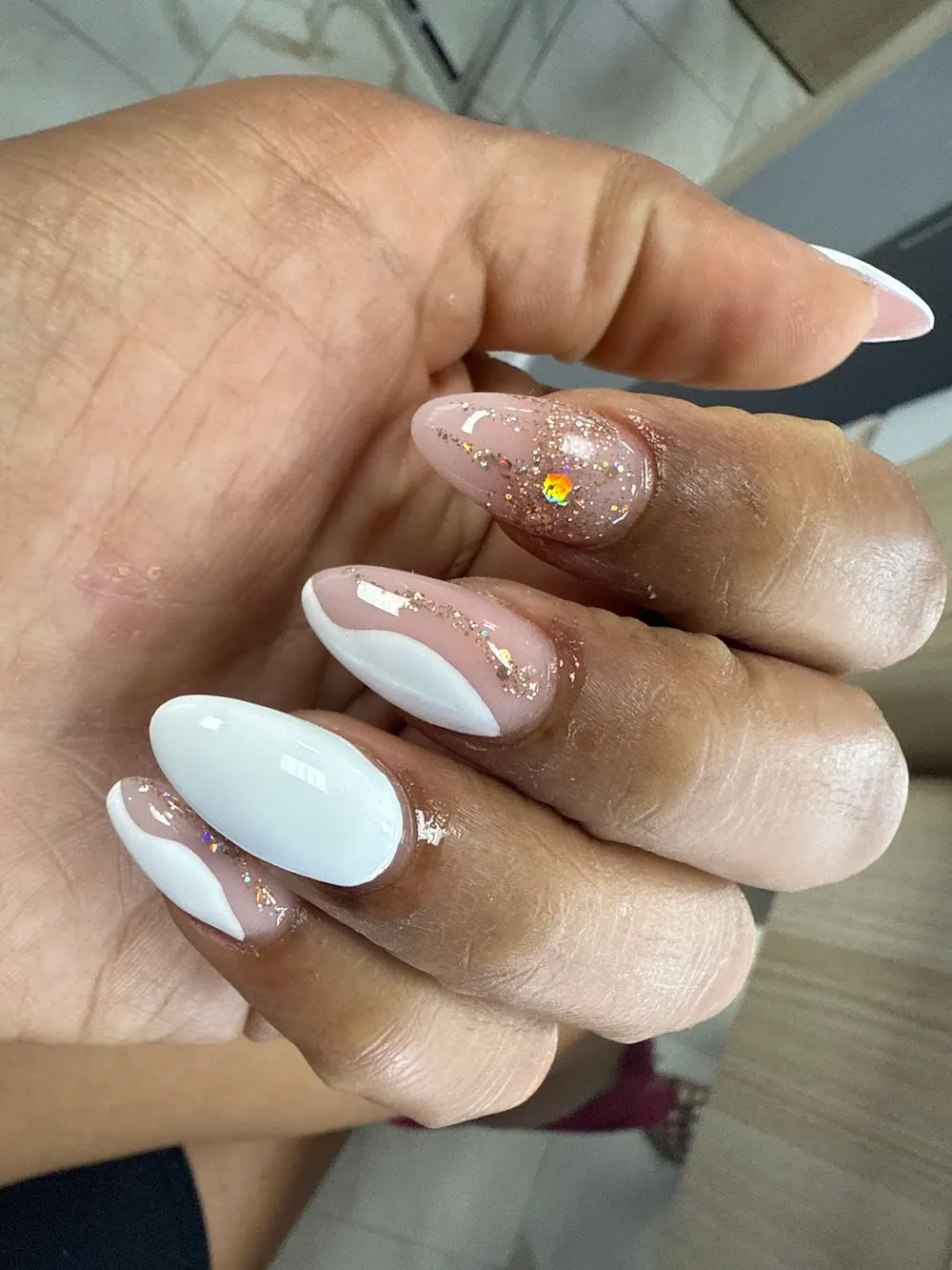 A guest's manicured nails with a soft gold finish at Hien Vu Nails in Champaign, Illinois